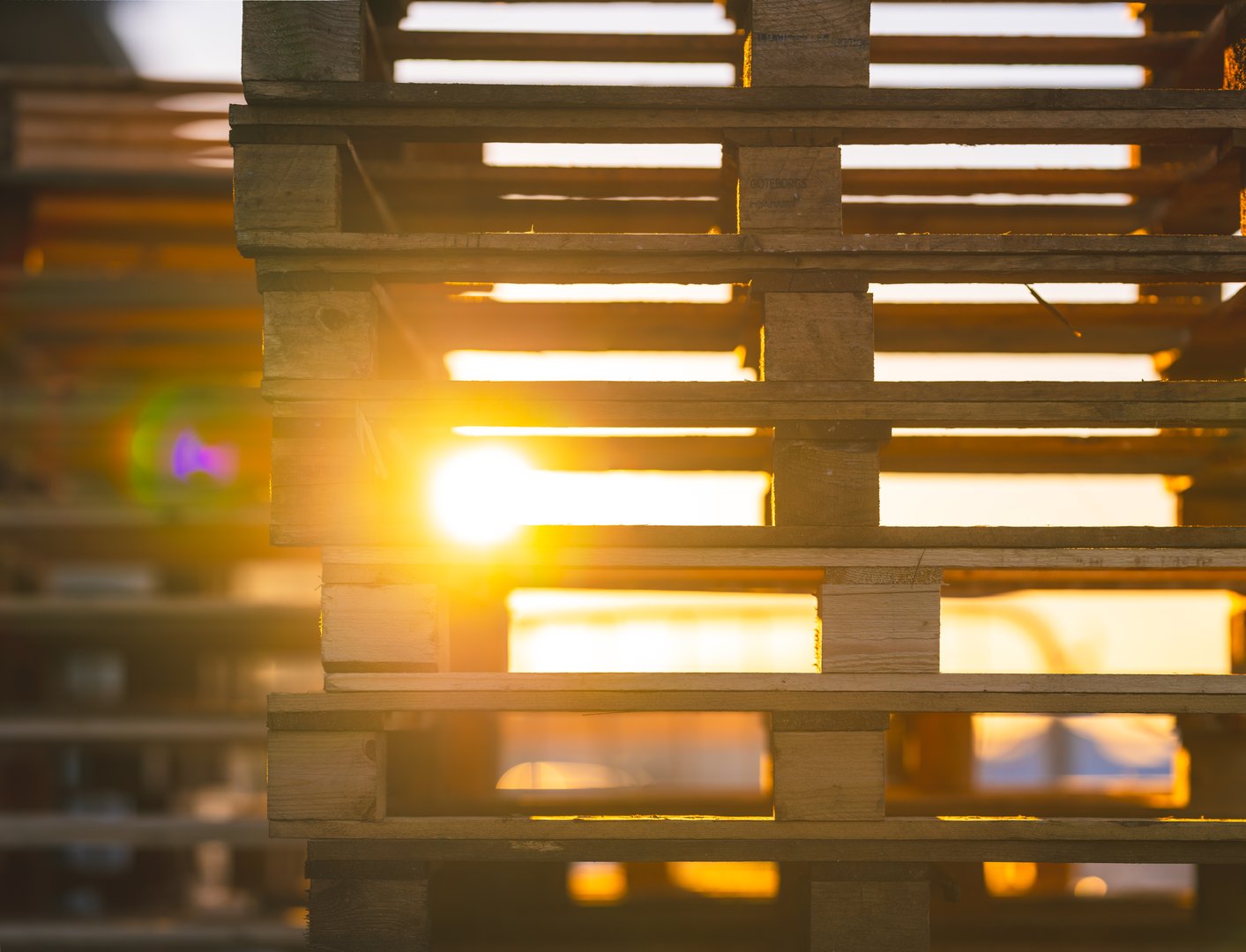 stacked wooden pallets with sunlight streaming through.