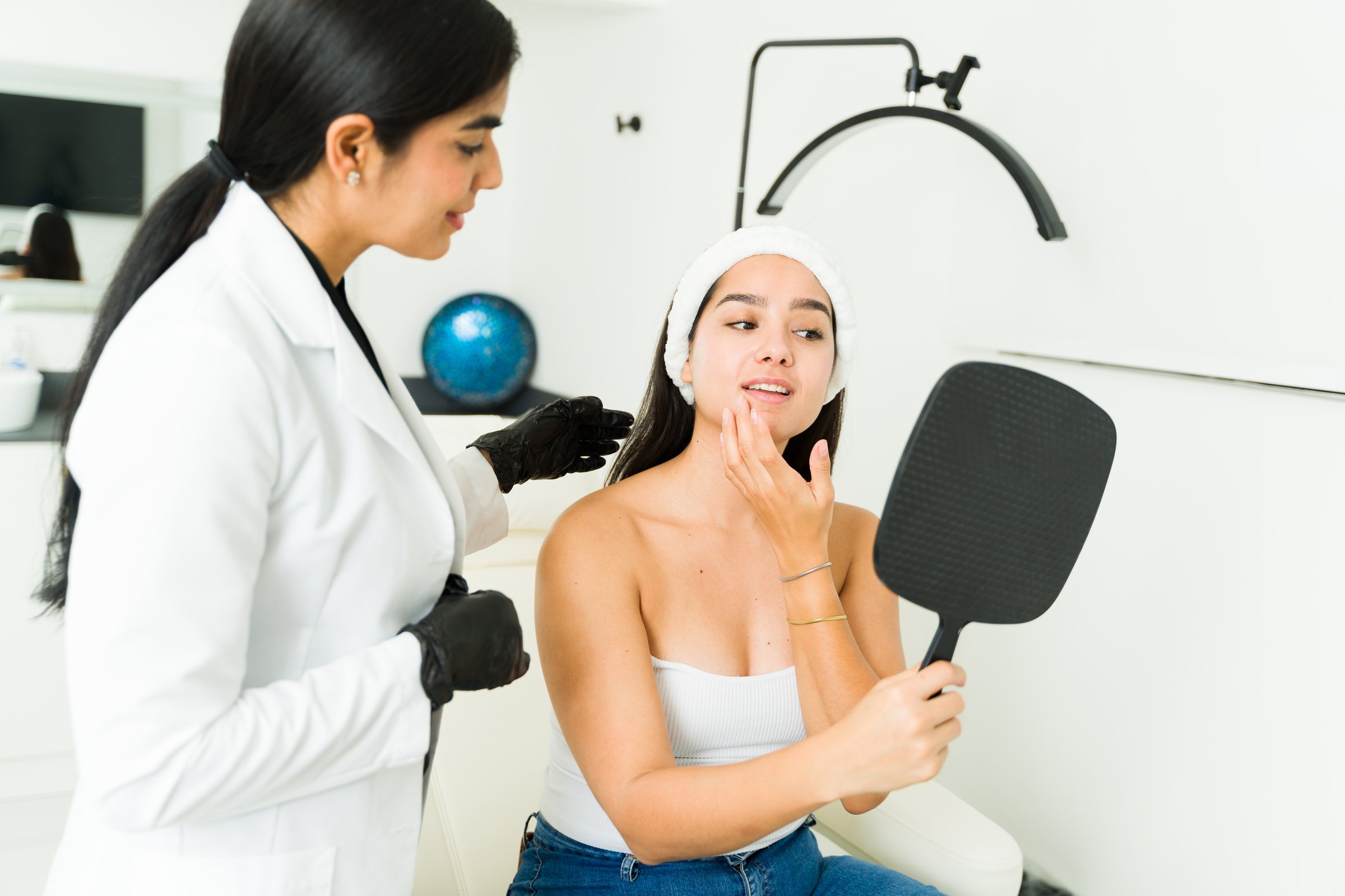 Professional cosmetologist discussing botulinum toxin treatment options with a patient in a modern clinic for beauty enhancements