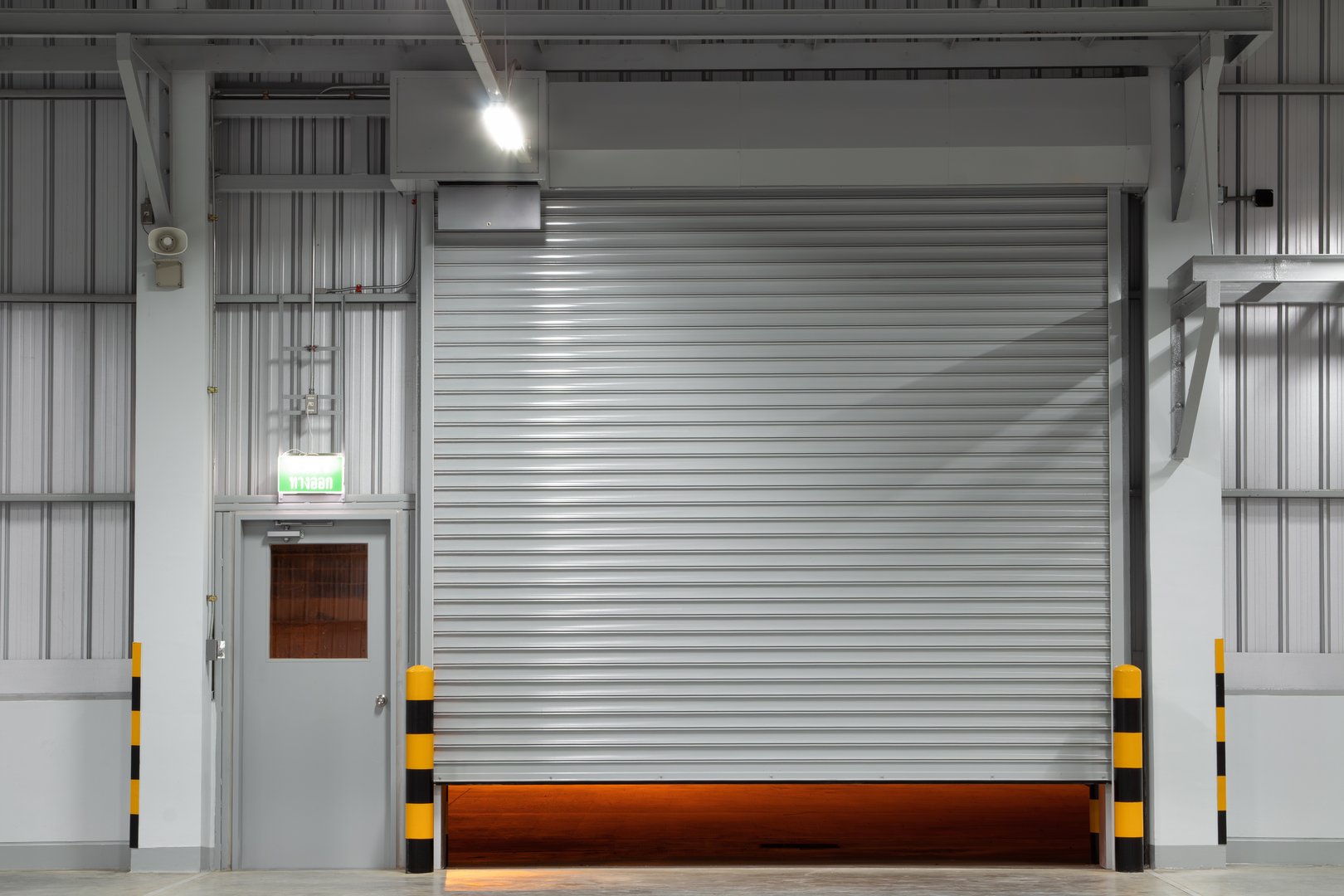 Shutter door or roller shutter inside industrial building at front. To construction for entrance of commercial, industrial building i.e. warehouse, factory, garage, hangar or shop suit for background.