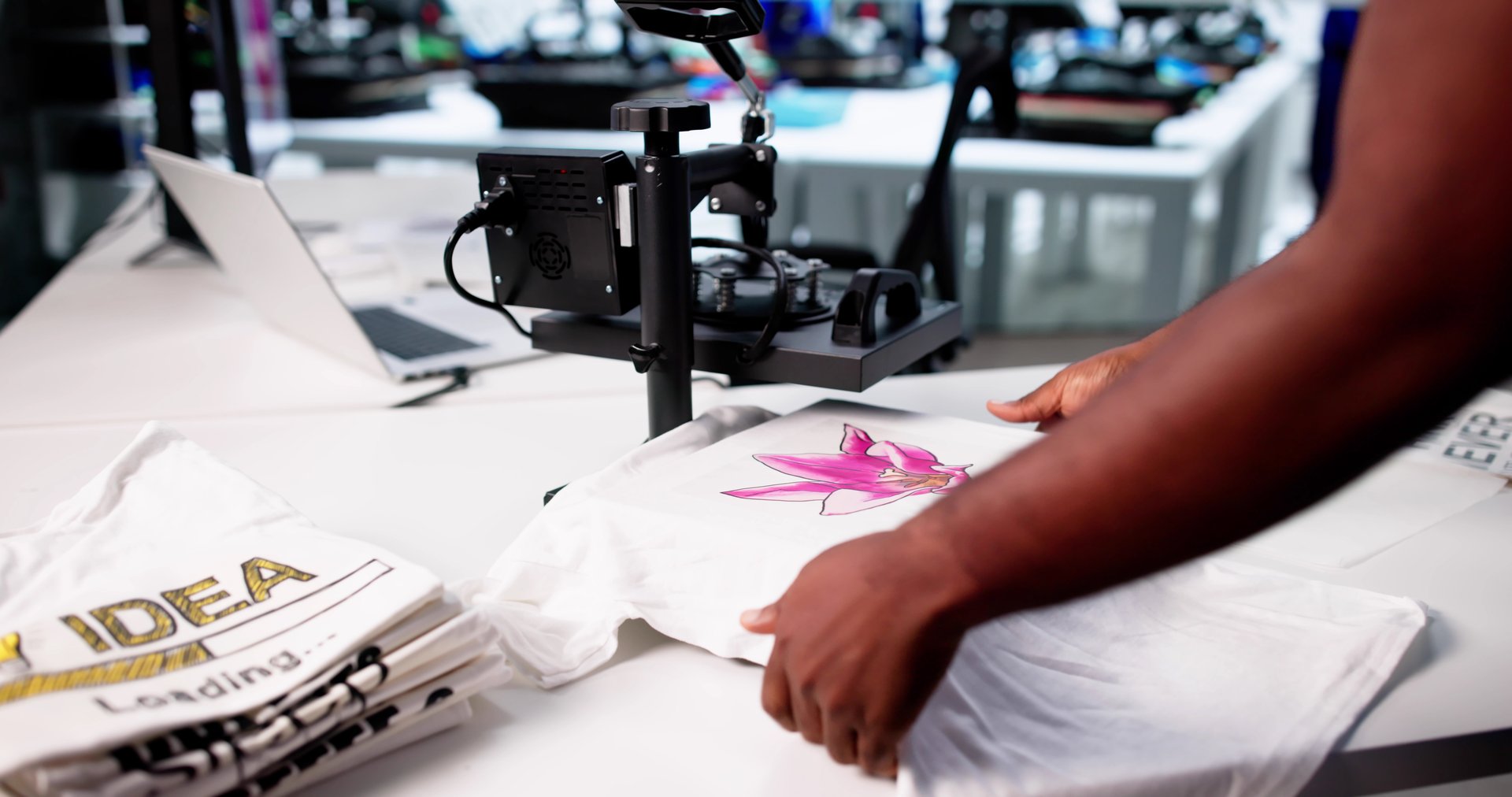 Young Black Man Operating Custom Digital Print T-shirt Cloth Heat Press Machine For Sale.