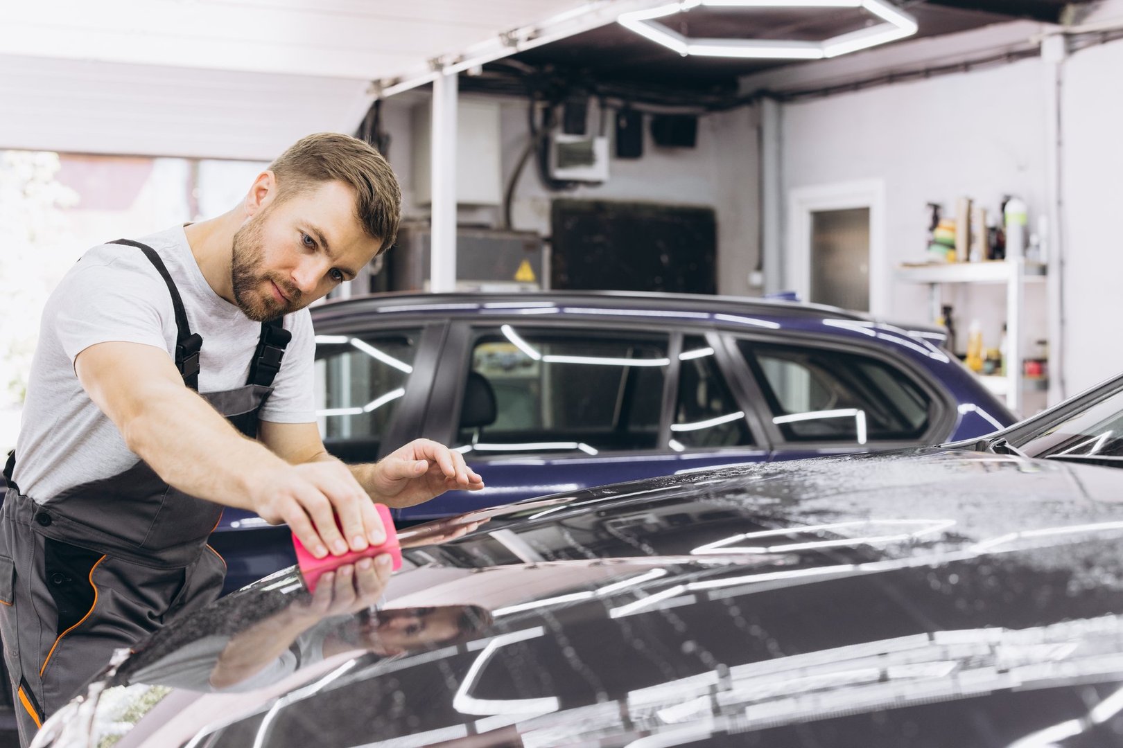 A car wrapping specialist applies a polyurethane film to the car. Selective focus. PPF protective film against chips and scratches. Car wrapping.