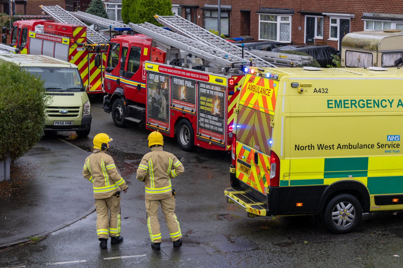 A photograph of the back of two firefighters surveying the scene of an emergency