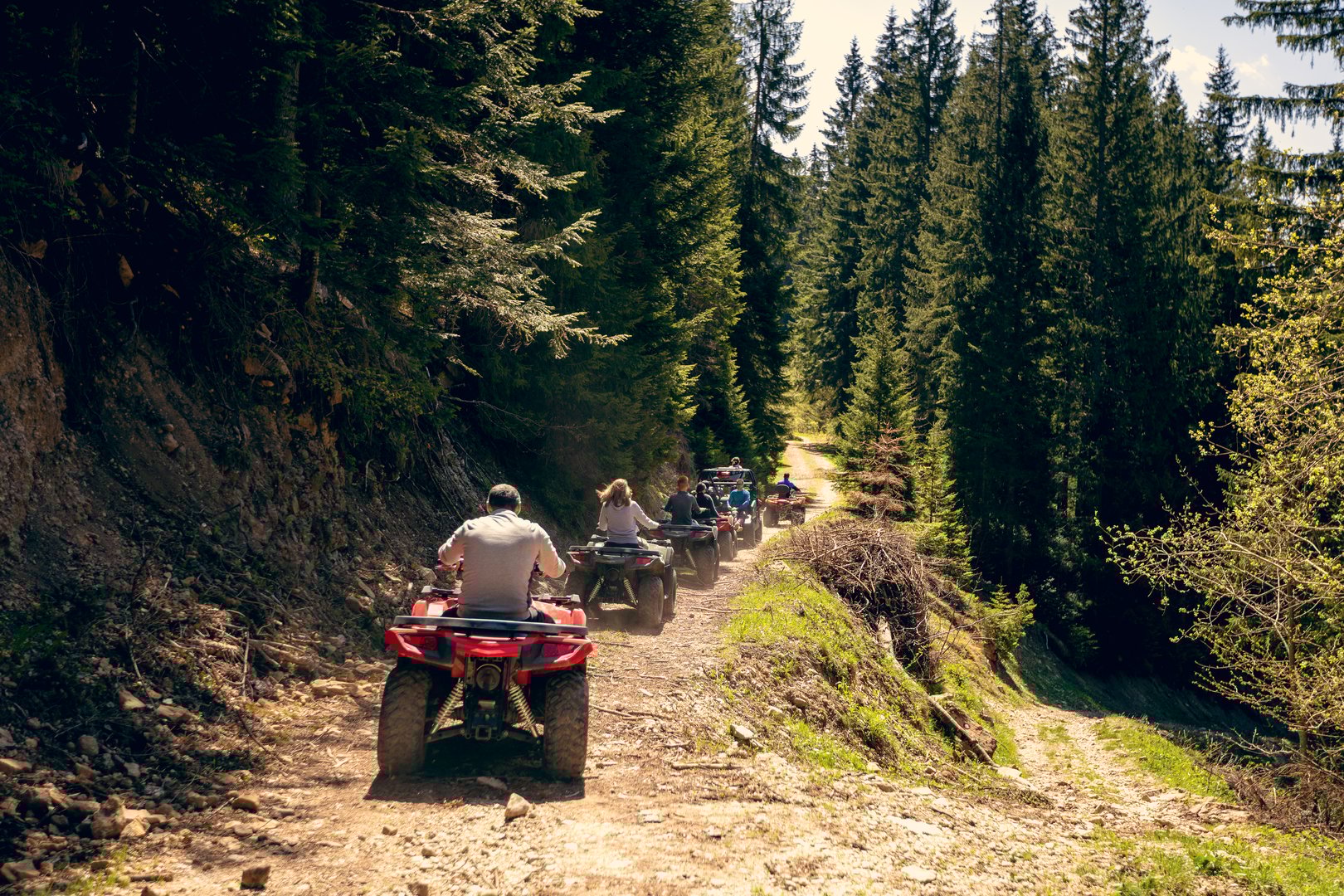 A tour group travels on ATVs and UTVs on the mountains.