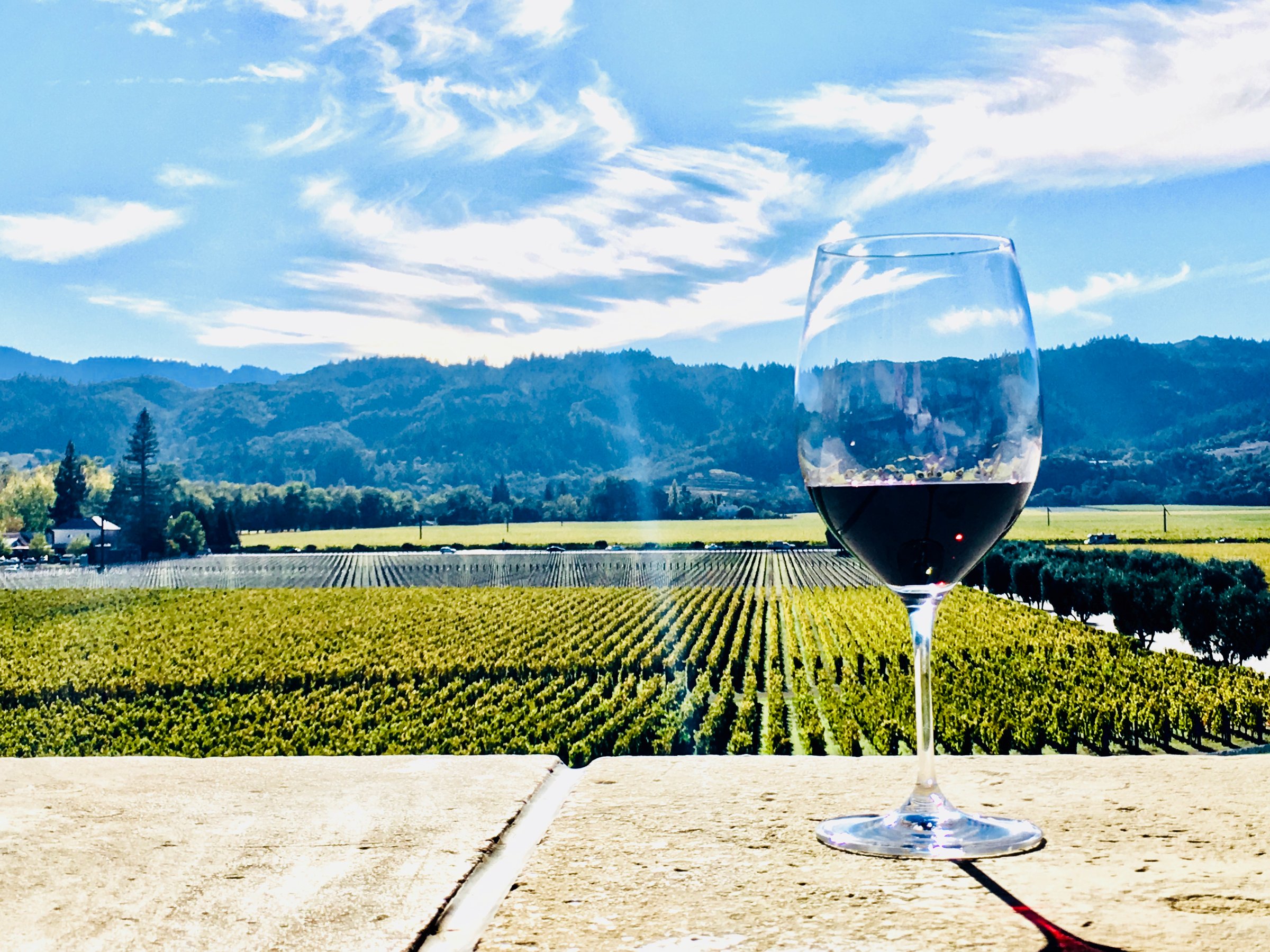 Glass of Cabernet Sauvignon overlooking vineyards in Napa