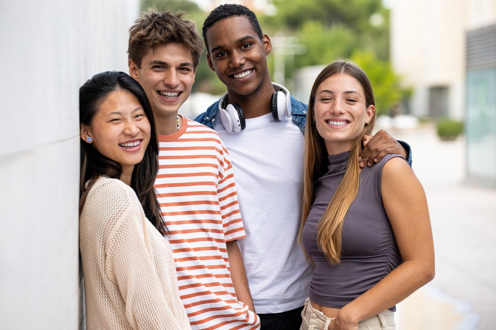 Group of happy friends  smiling and looking at camera. Diverse group of joyful millennial people staring happy at camera.