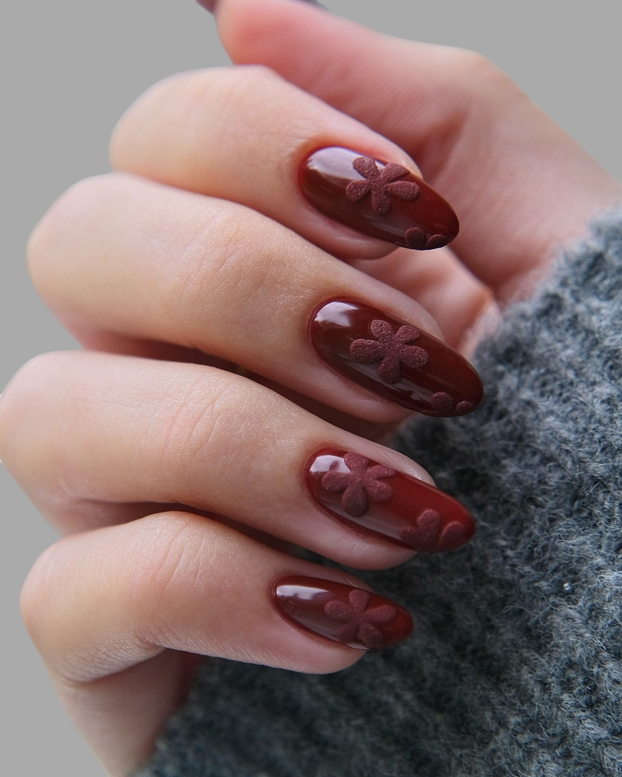 Young woman's hands with modern and stylish innovative nail manicure with elegant shapes and drawings with light background