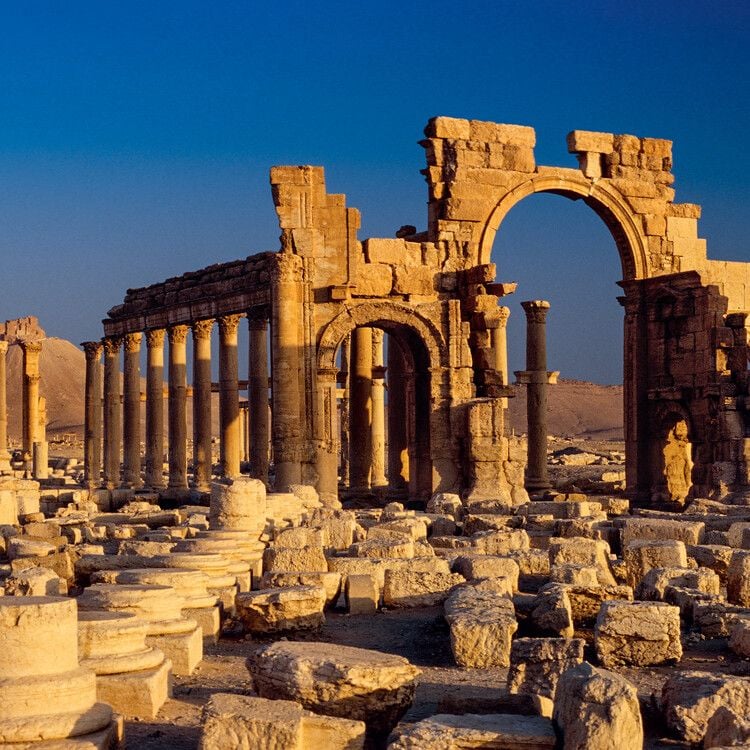 Ancient ruins of Palmyra showing the monumental arch and colonnaded street in the Syrian desert