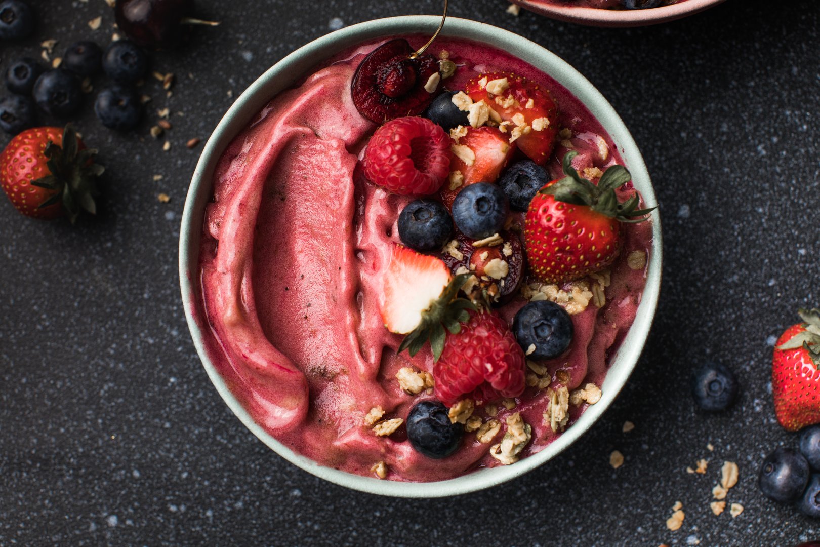 Acai breakfast superfoods smoothies bowl topped with bee pollen granola coconut flakes and blueberries. Overhead top view flat lay