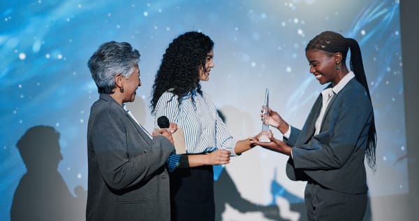 Women, award and happy on conference stage, mic and giving prize for performance at company. Person, staff and trophy at event with thanks, goal and smile for reward with success in finance career