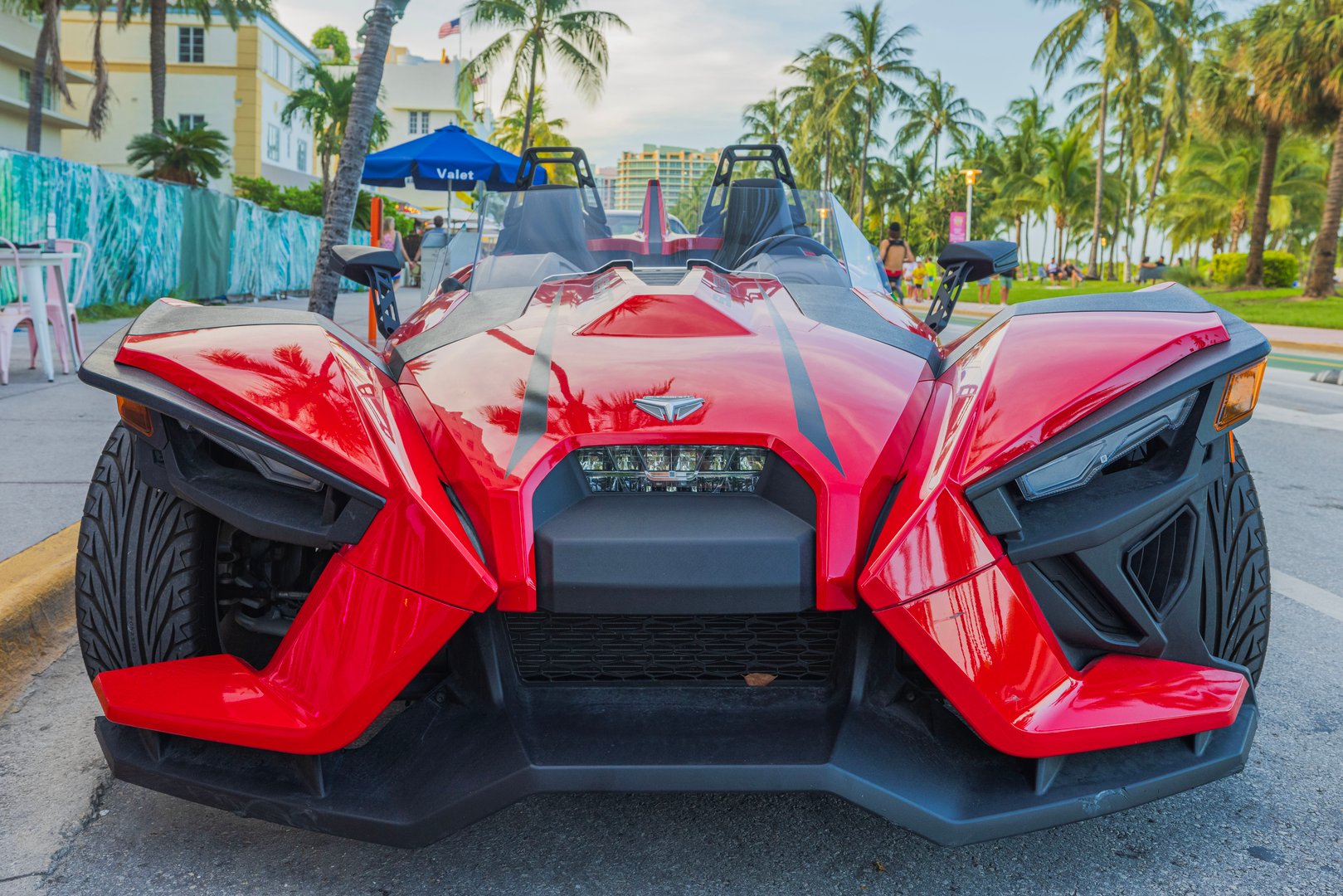 Florida. USA. 11.12.2023. Close-up view of front red Polaris Slingshot parked on Ocean Drive in Miami Beach.