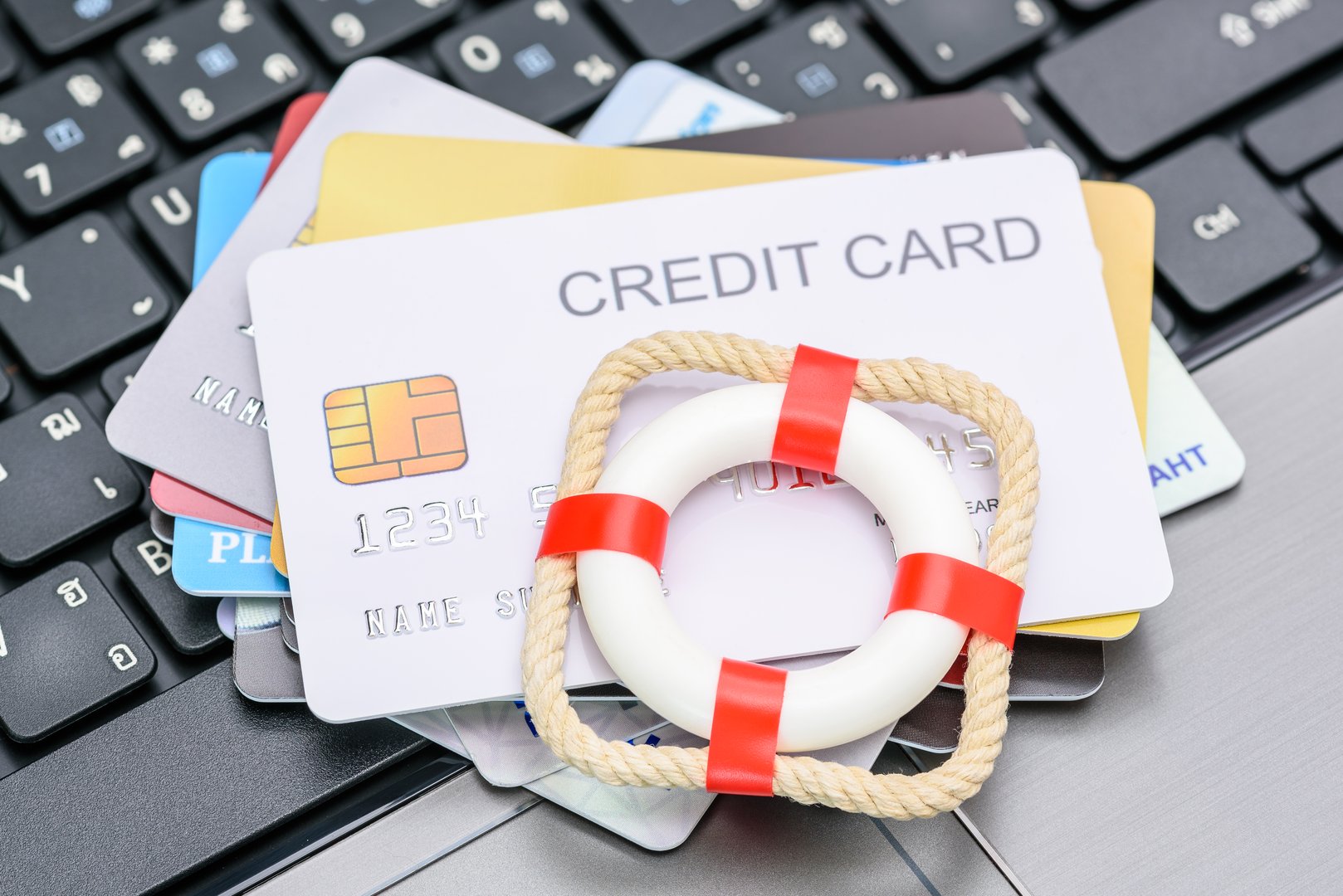 Household and credit card debt on a lifebuoy atop credit cards