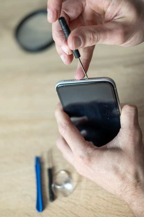 Technician repairing smartphone with precision tools. Close-up of hands fixing mobile phone hardware components, technical support, DIY repair, service center, phone hardware