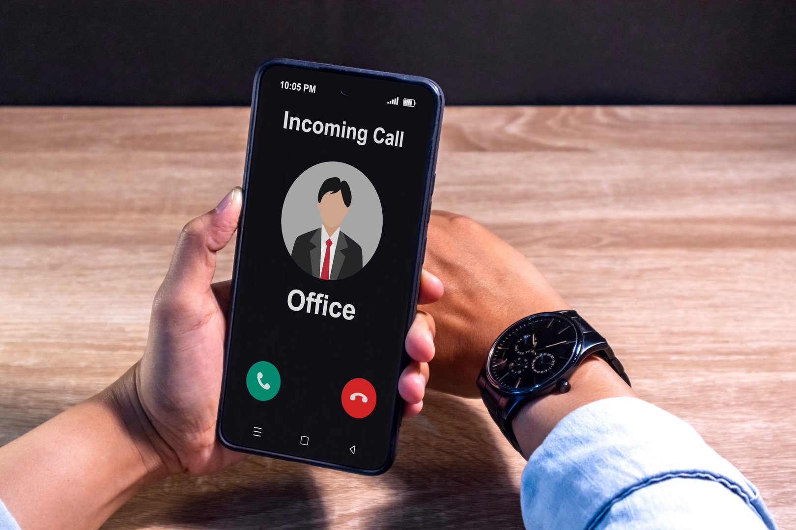 Hand holding a smartphone with incoming call from office at night after business hours. Right to disconnect concept.