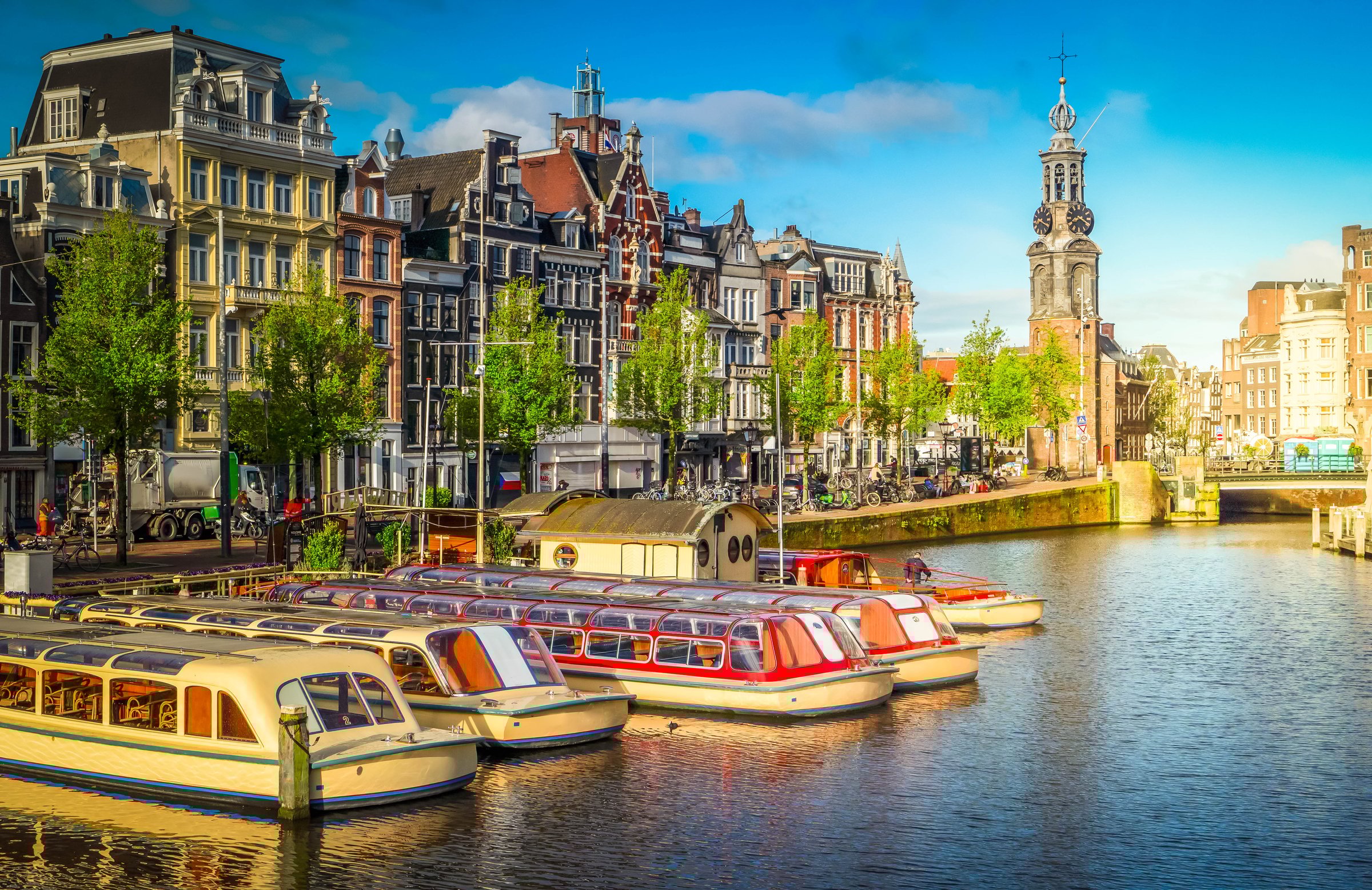 Moored boats and facades of old historic Houses over canal water, Amsterdam, Netherlands
