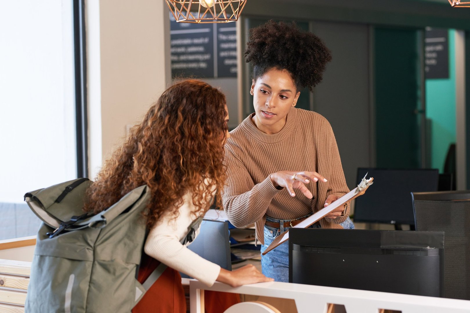 Young woman checks in at front desk, reception, hotel, college library admission. High quality photo