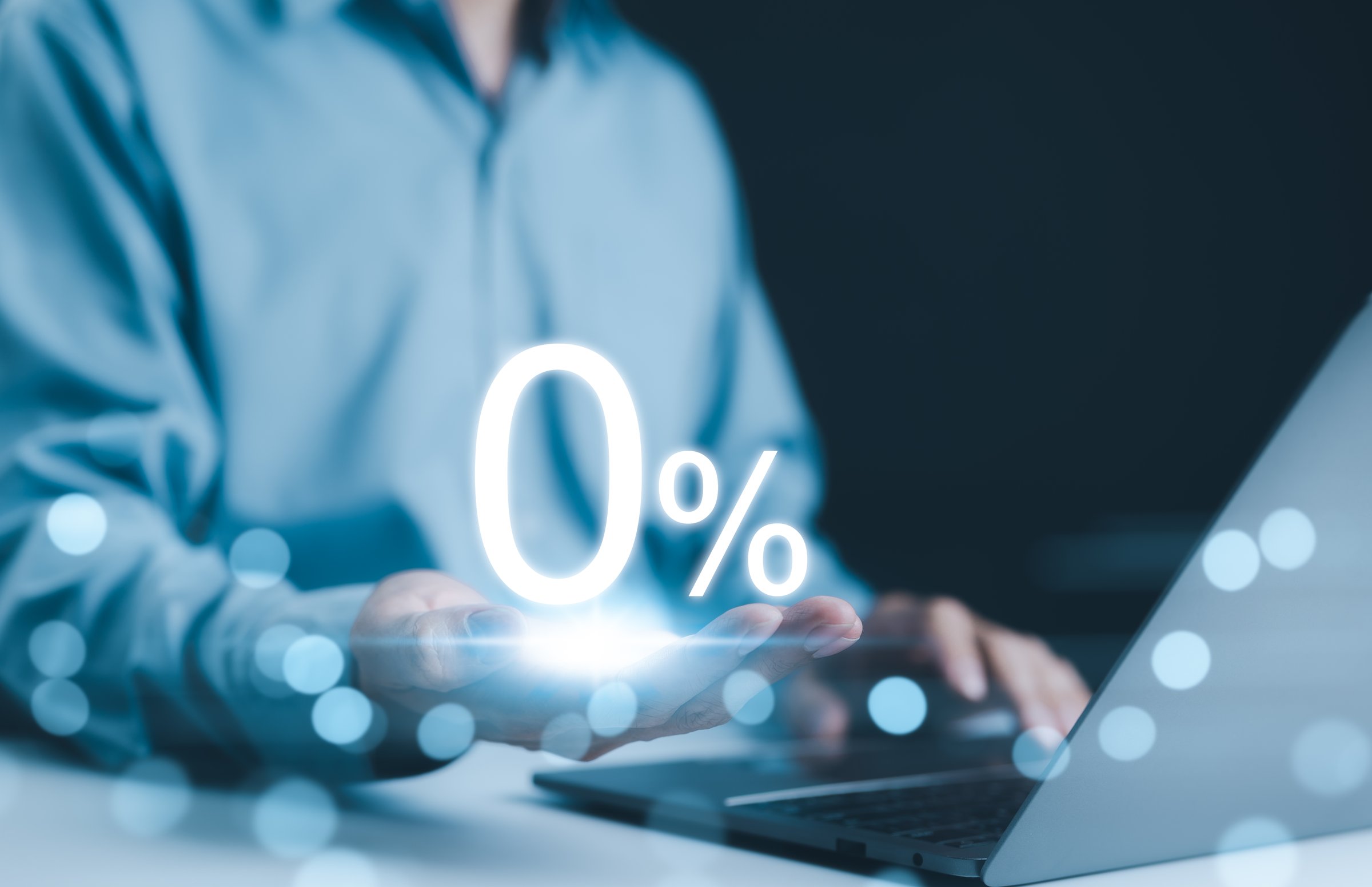 Zero Percent Interest Rate. Businessman holds glowing 0 percent symbol in his hand, symbolizing zero percent interest or financing. financial context, discount, and no commission, sale promotion,