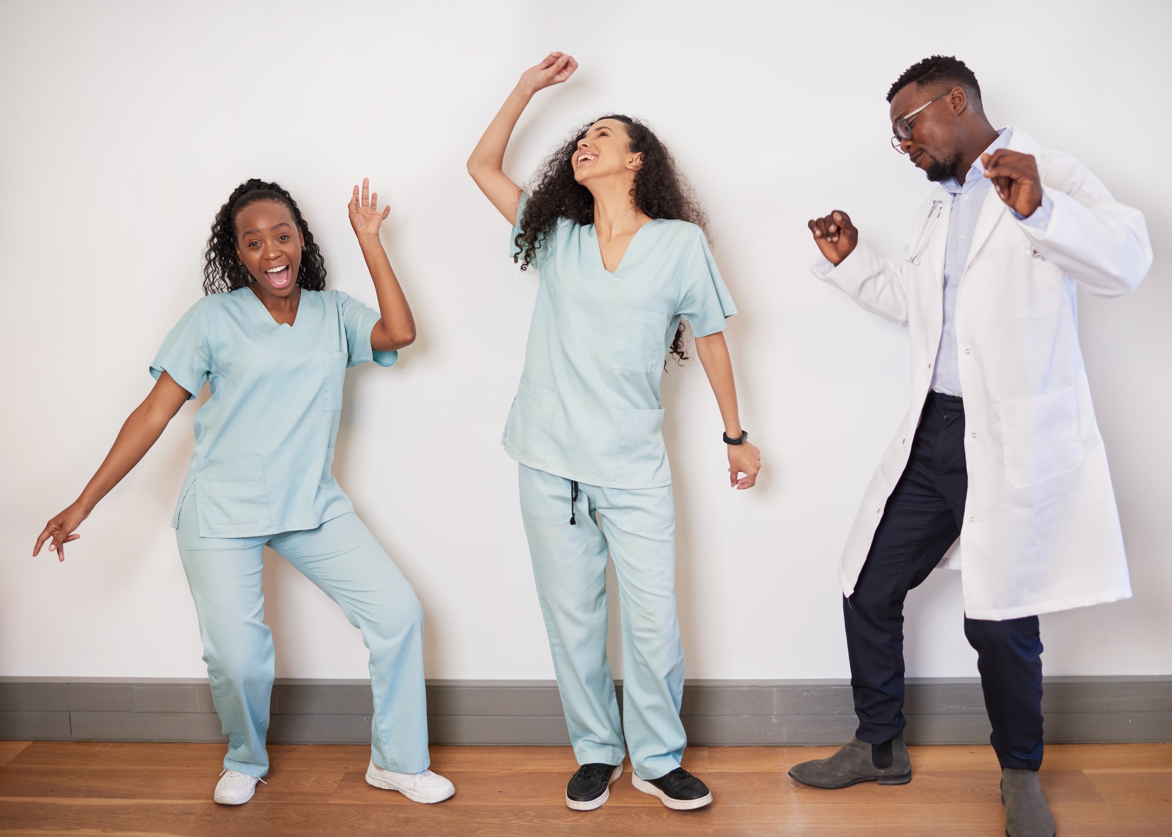 Team of three medical professionals dance on a break, doctor having fun. High quality photo