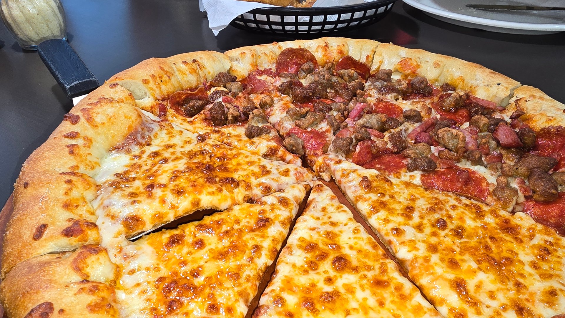 Delicious pizza featuring a combination of cheese and meat lovers toppings, served on a wooden board. The golden cheese stuffed crust and melting cheese emphasize fresh and irresistible flavors, creating a mouthwatering culinary experience.