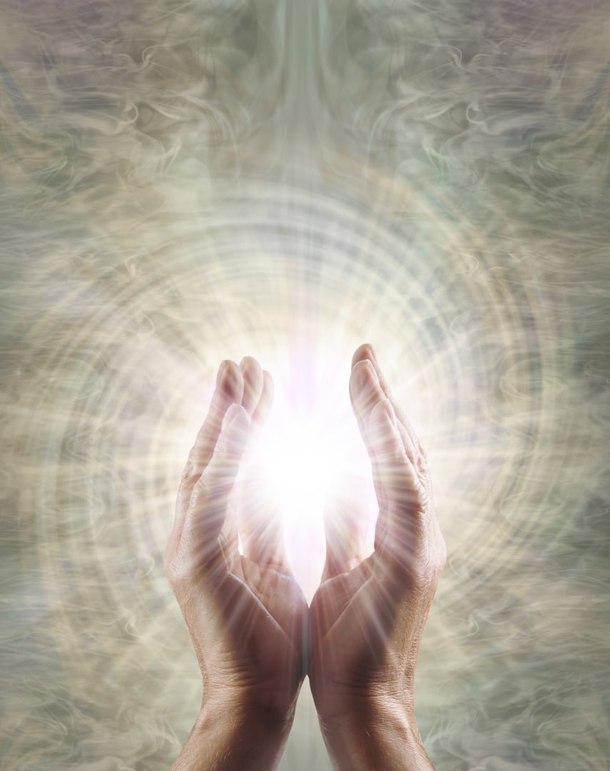 male parallel hands with white star light between against a spinning vortex copy space background ideal for a spiritual holistic healing theme