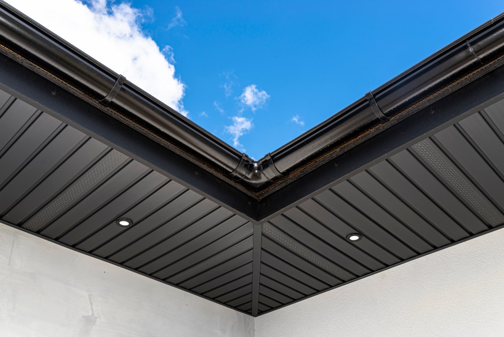 A modern graphite herringbone roof lining is attached to the trusses, visible turned on LED lights