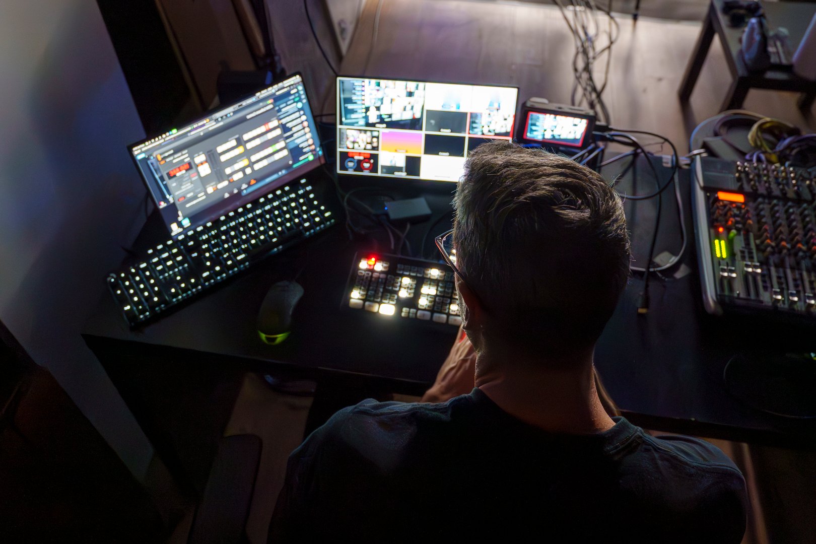 Video director managing multiple screens in control room during live broadcast