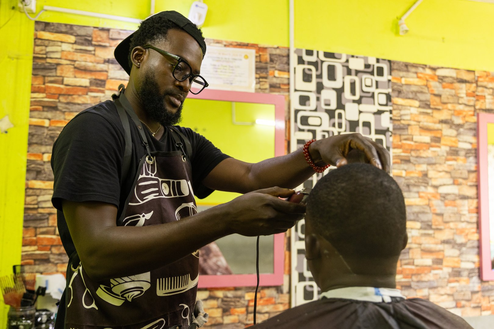 A barber is focused on cutting his client's hair in his salon.