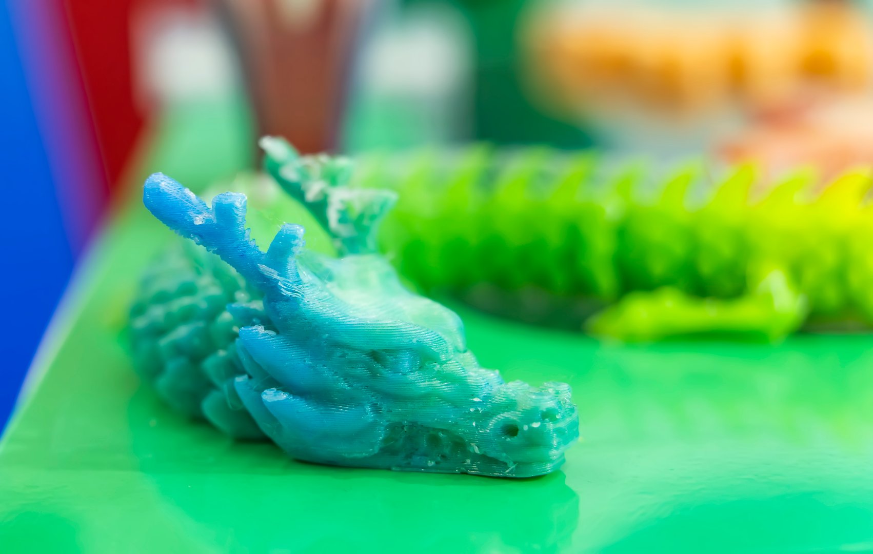 3D printer printing dragon head figure close-up.