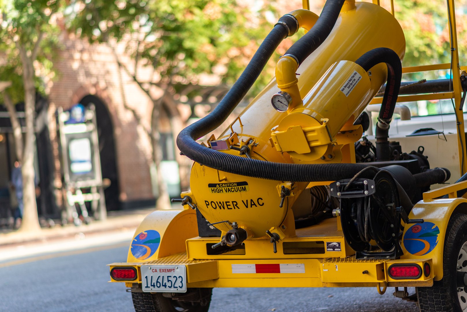 A yellow street power vacuum truck parked in Santa Monica, Los Angeles, California, USA