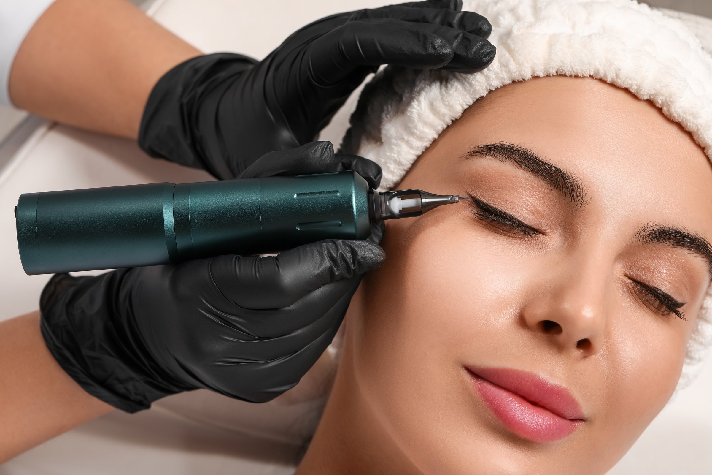 Young woman undergoing procedure of permanent eyeliner makeup, closeup