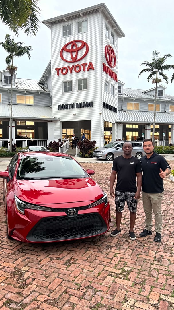 Cliente satisfecho mostrando su nueva inversión automotriz