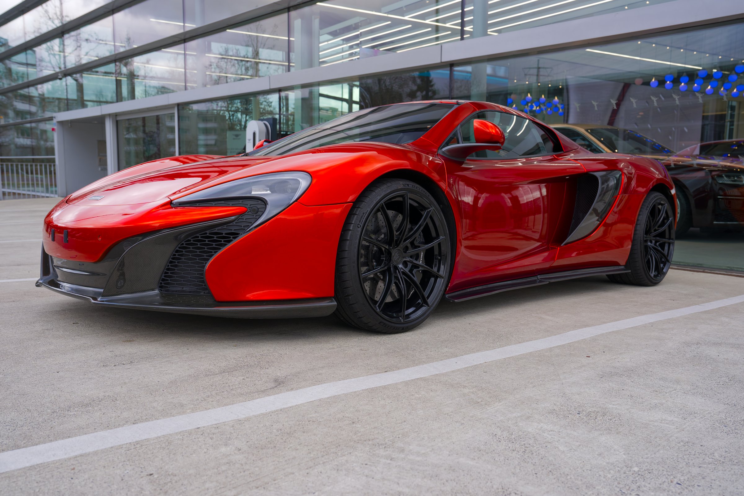 Close-up of red orange colored luxury Mclaren sports car parked at car dealership. Photo taken December 6th, 2024, Opfikon Zurich, Switzerland.