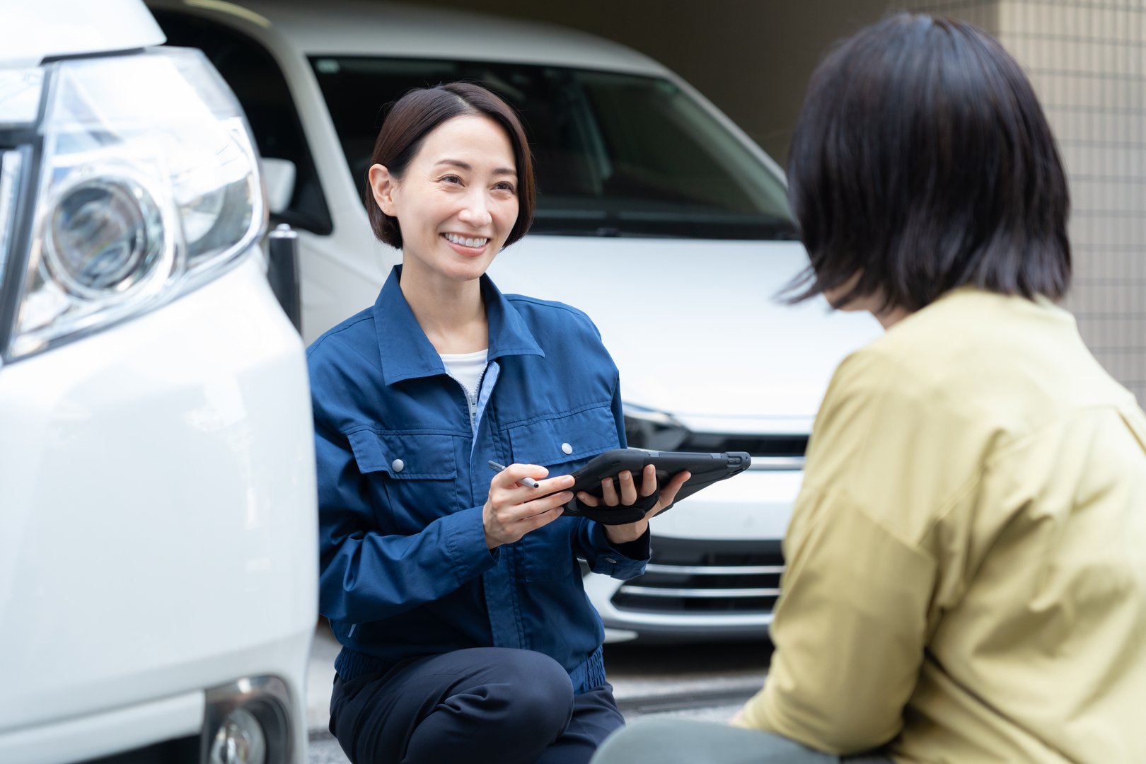 Middle-aged female auto mechanic repairing a car