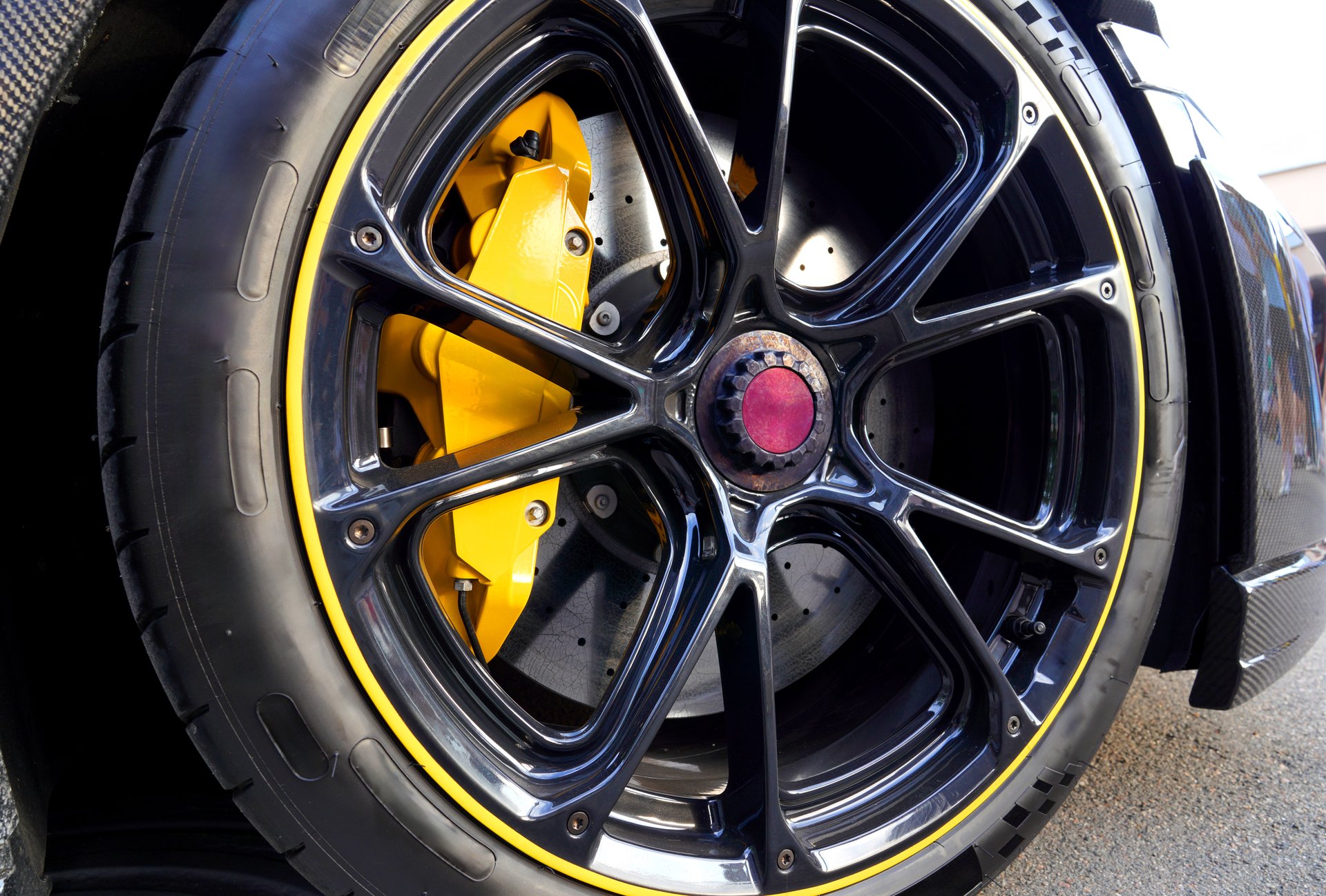 Alloy wheel with calipers and racing brakes of the sport car. Racing brake disc and low profile tyres. Lower-profile tires of drag and drift cars. High-performance sports cars.