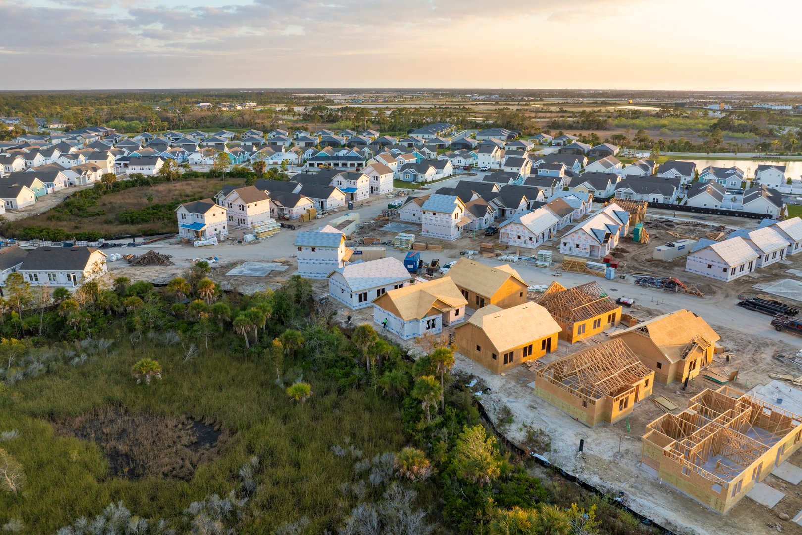 Wooden houses under construction in new developing suburban area. Development of residential housing in American suburbs. Real estate market in the USA.