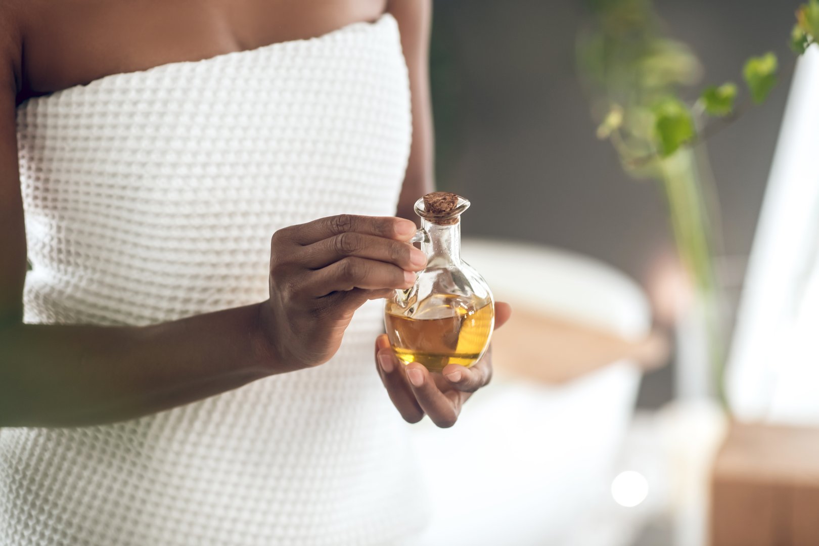 Oil, hair care and face of black woman in studio for self care with keratin for growth. Happy aesthetic model with natural curly afro and salon cosmetic serum product for shine and health benefits