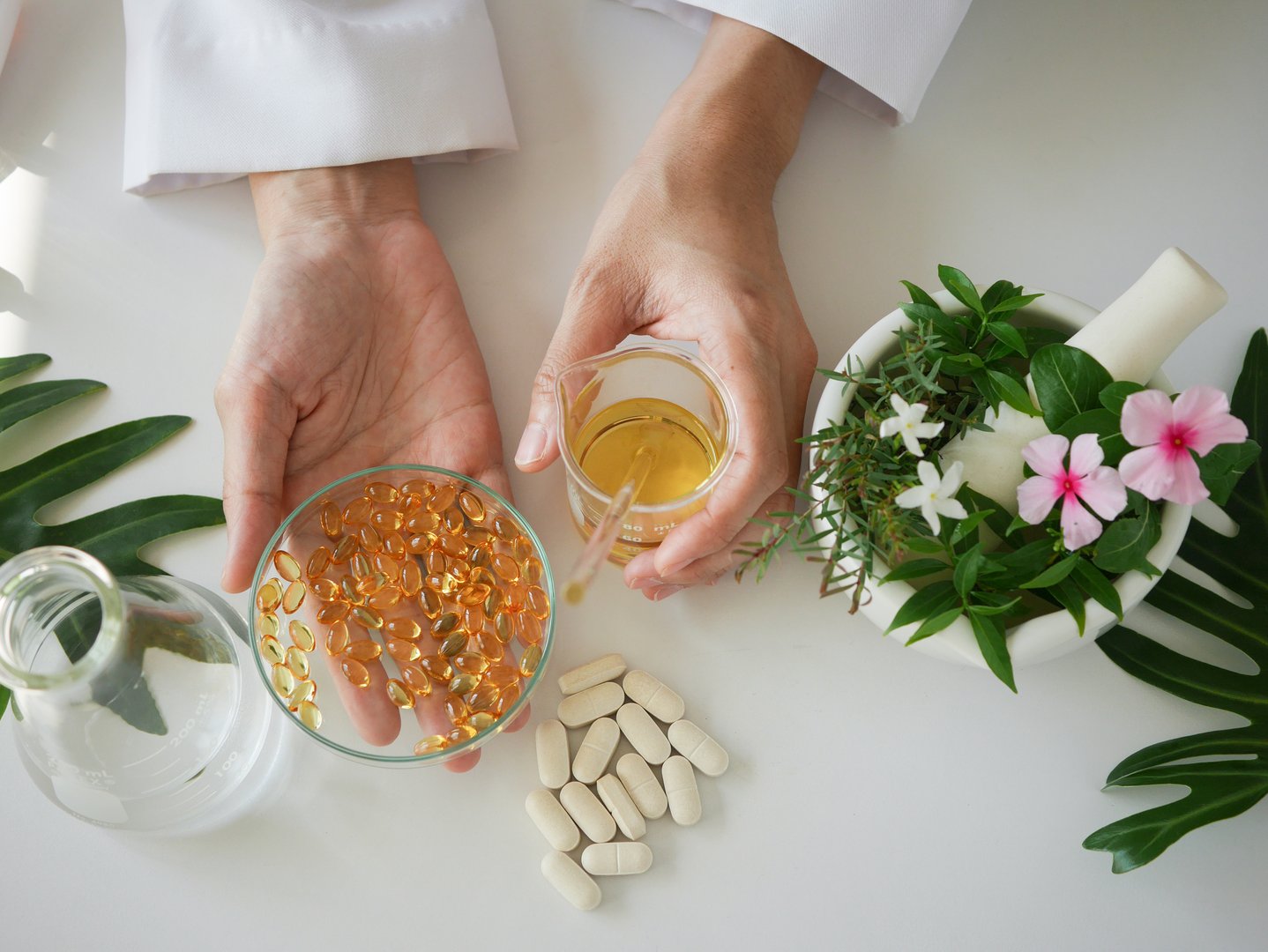 scientist or doctor making herbal medicine with herb leaves , capsule, tablets. hands.top view.