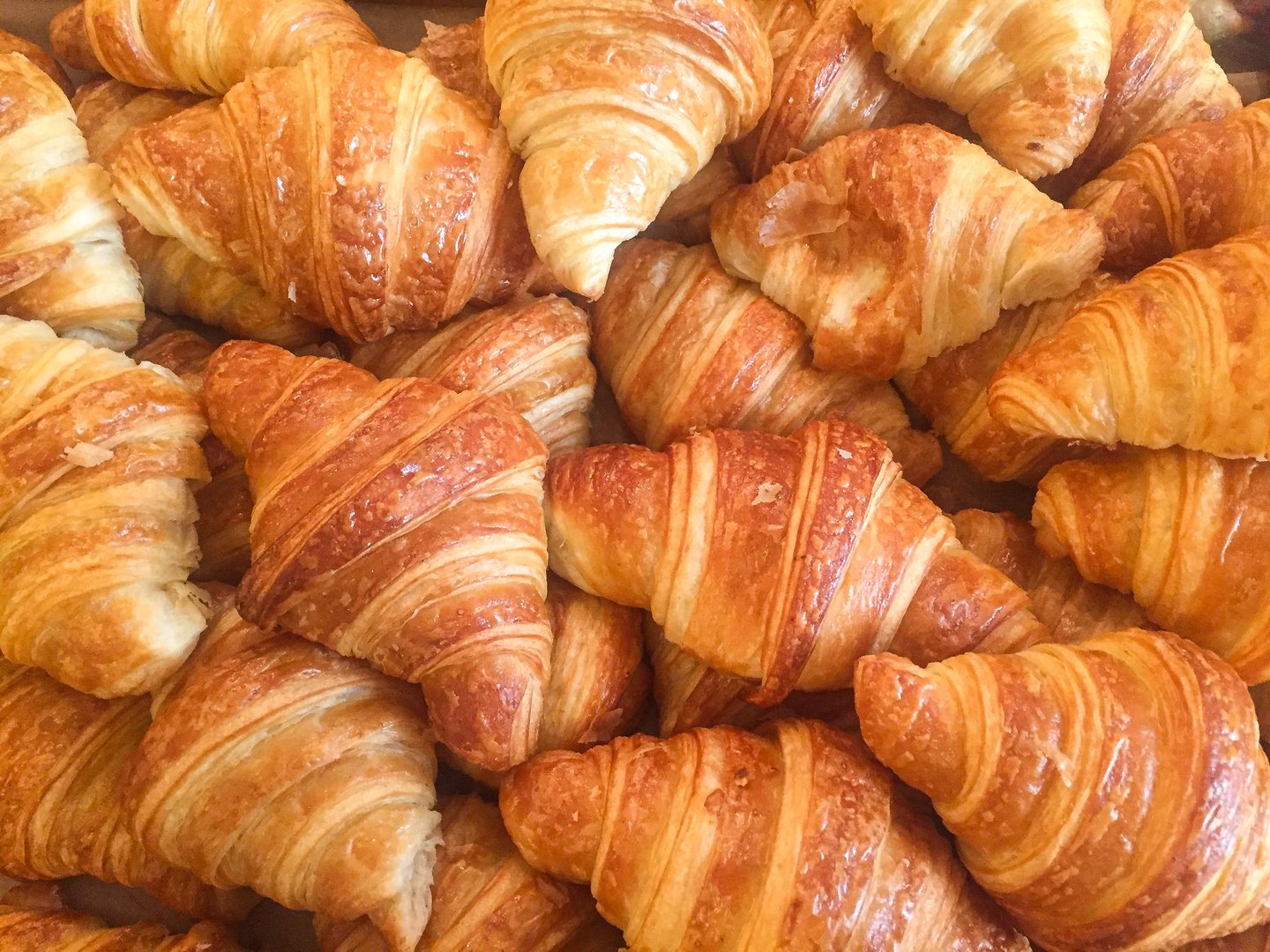 Close-up of freshly baked golden croissants stacked together