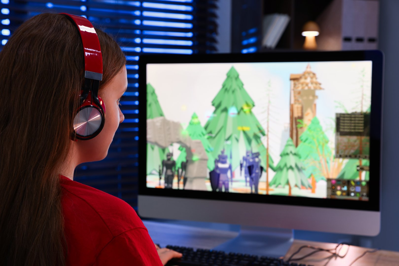 Girl watching game live stream at table with computer keyboard