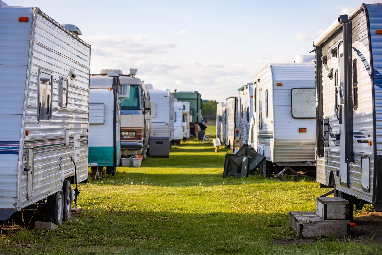 Peaceful campground scene featuring campers side by side on a lush green field, perfect for outdoor adventures and family getaways.