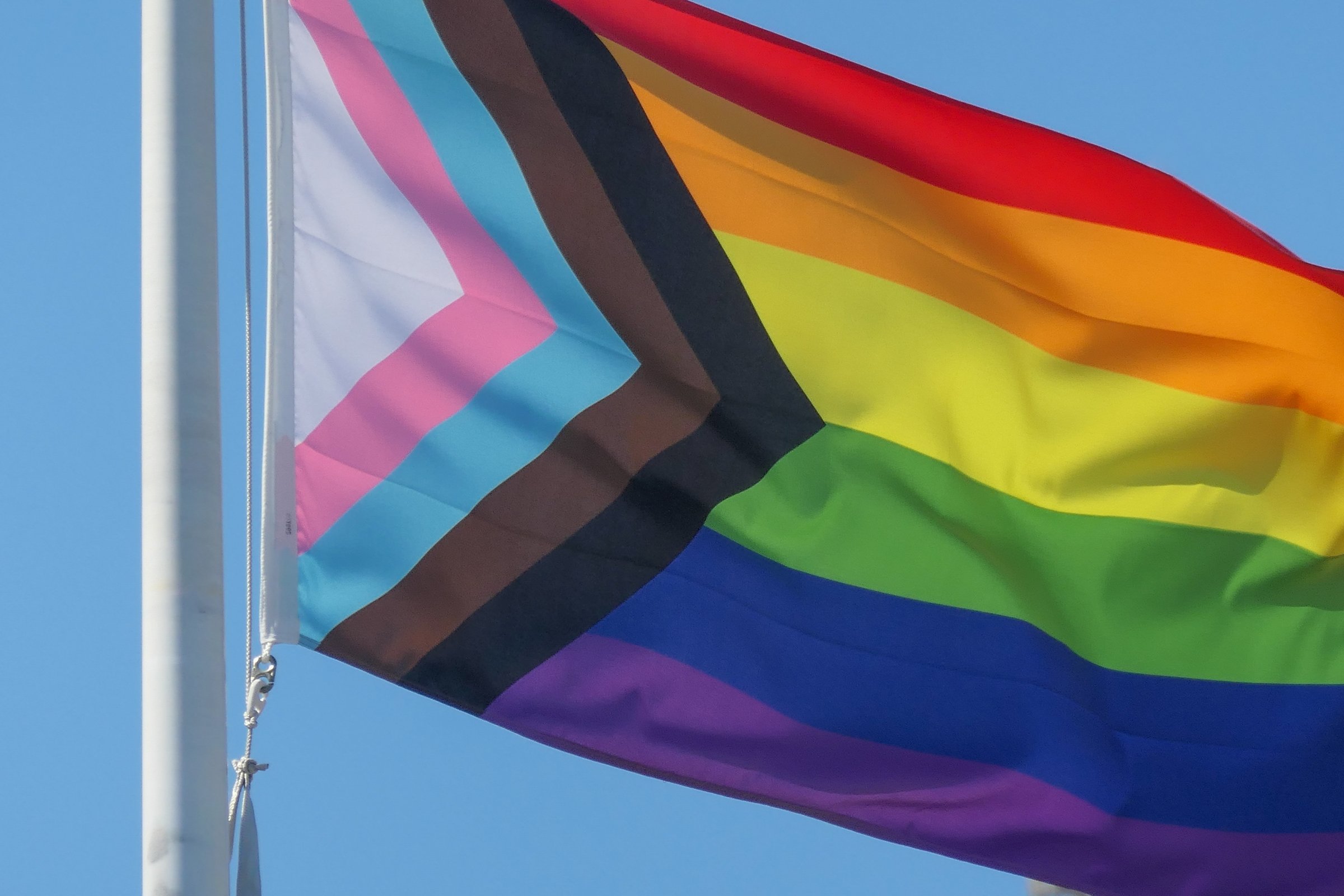 The Pride Progress Flag flies on a flagpole outside a hotel on O'Riordan Street, Mascot near Sydney Kingsford-Smith Airport. This image was taken on a sunny afternoon on 30 March 2024.