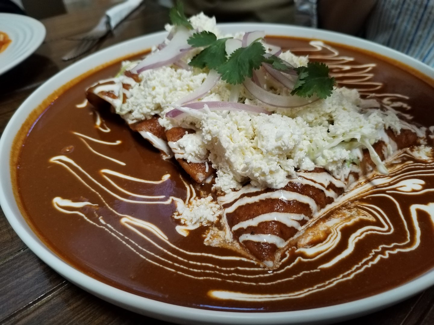 Enchiladas of mole poblano known as enmoladas Mexican breakfast. Tortilla corn with shredded chicken and mole poblano sauce