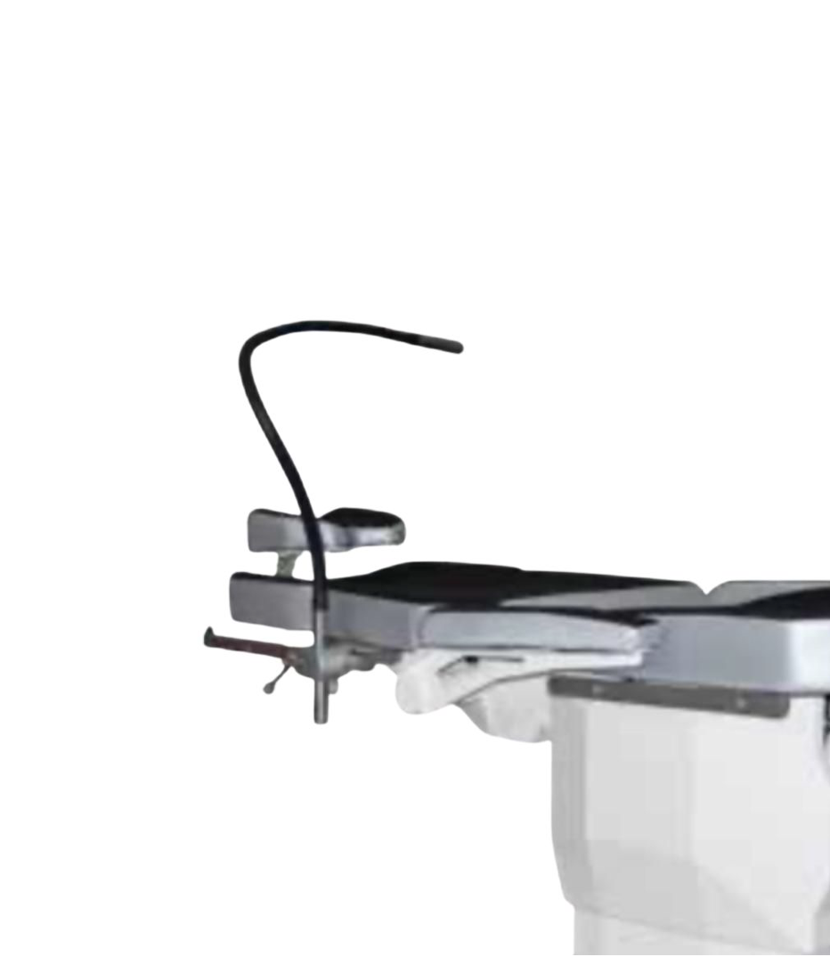 A modern medical examination table with adjustable armrests and an overhead light in a clinical setting.