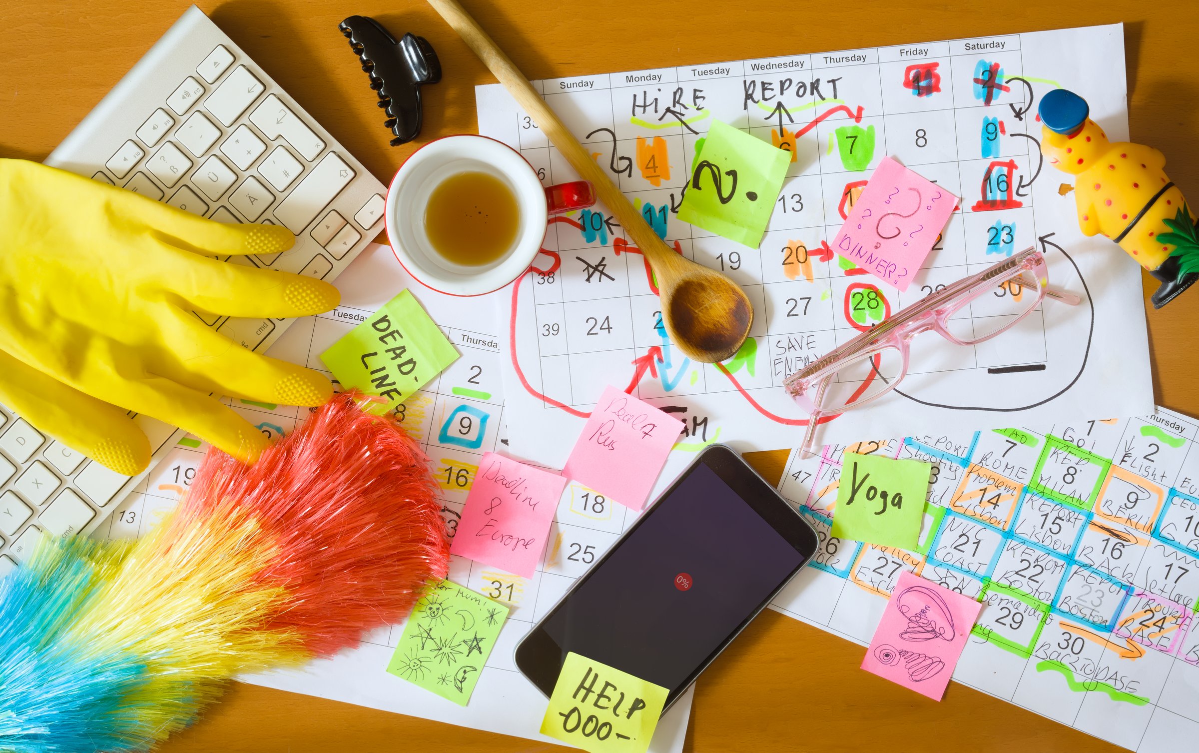 Messy cluttered workplace with cleaning and household utensils.Dual burden of women working in the home office: household chore and business,overworked, mental burnout.