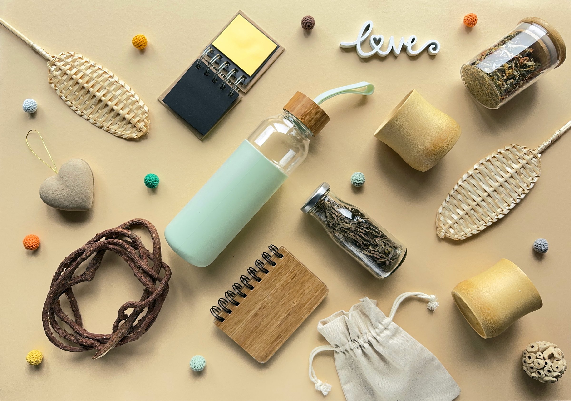 Zero waste tea background, various low impact alternatives to disposable objects in making tea. Geometric arrangement, knolling on pale yellow paper background