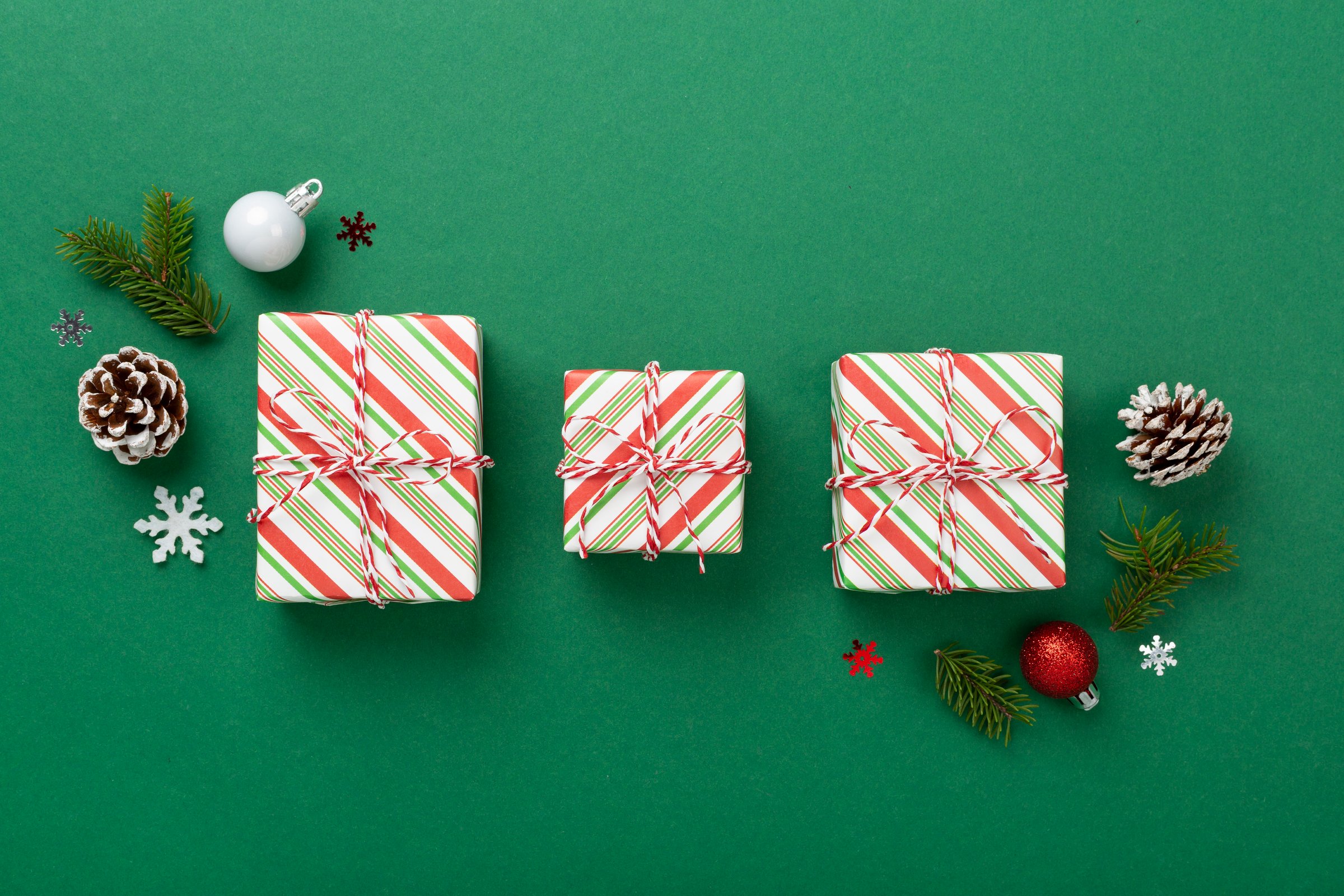 Striped Christmas gift boxes on color background, top view