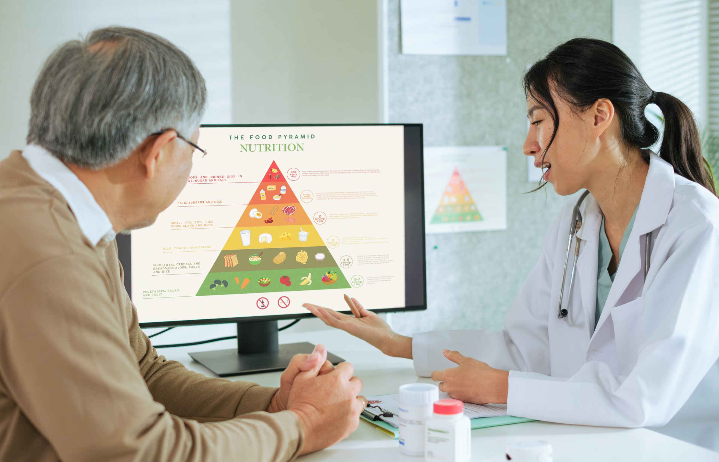 Doctor Explaining Healthy Eating and Food Pyramid to Senior Patient During Nutrition Counseling