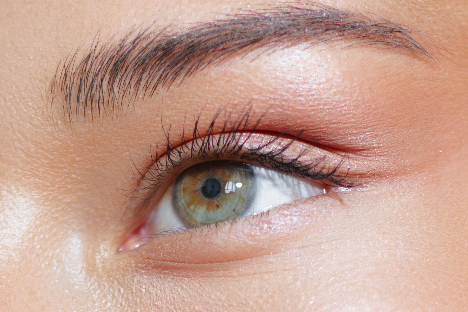 Extreme close-up of a woman's green eye with perfect makeup, highlighting the detail of eyelashes and skin. Ideal for beauty, makeup promotions, high-quality ads, and conceptual visuals.