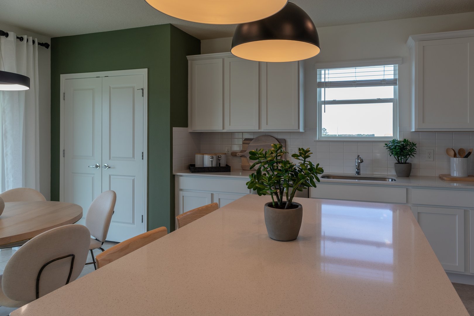 White cabinets in modern farmhouse kitchen with white counter tops and breakfast nook
