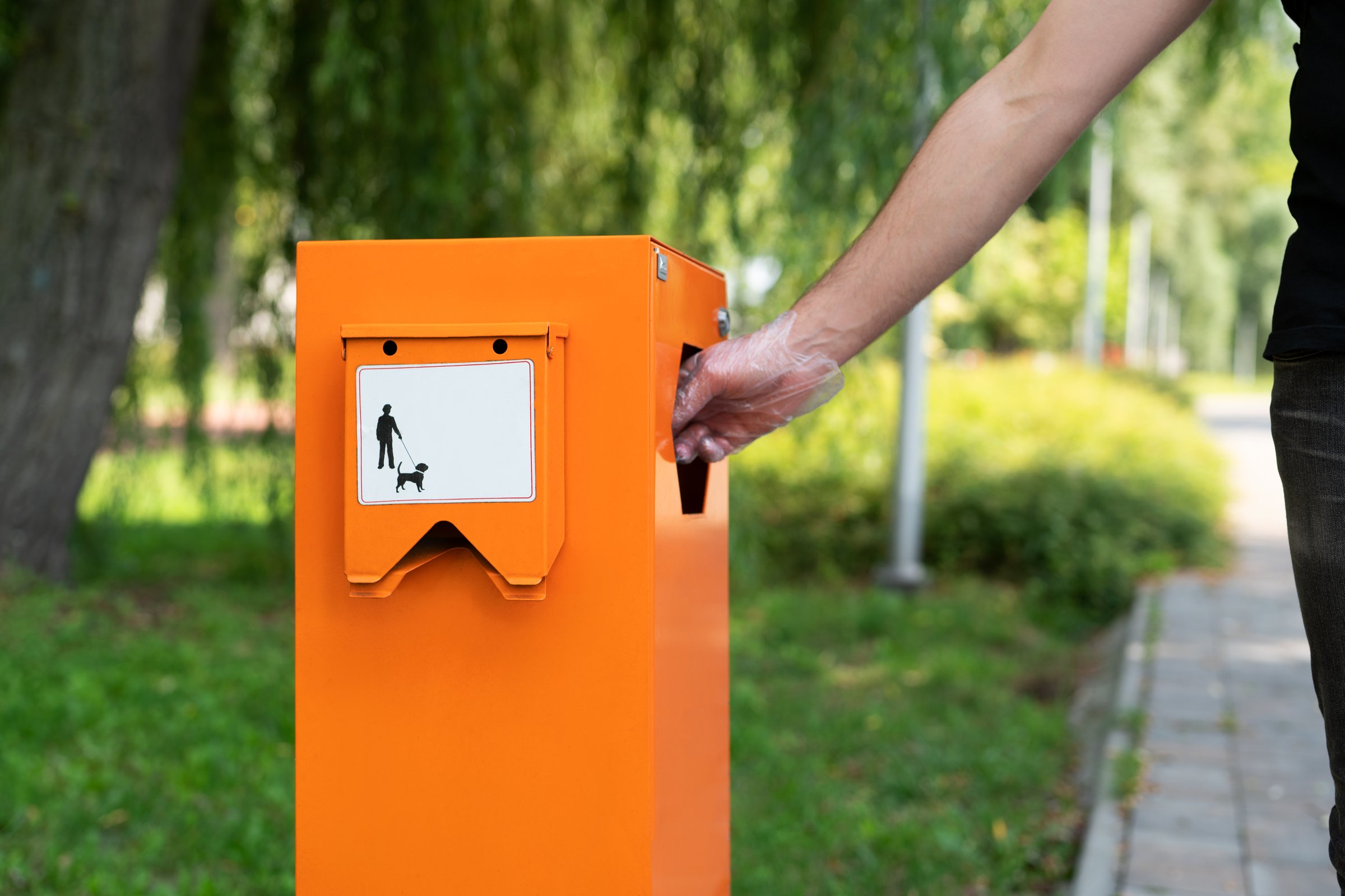 Pet waste station with dog poop bags and garbage in the park