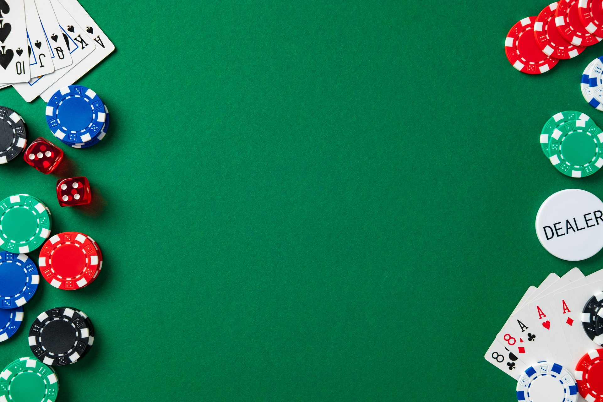 Casino game elements frame green background from corners. Poker chips, cards, dice, dealer button. Flat lay gambling concept with central copy space.